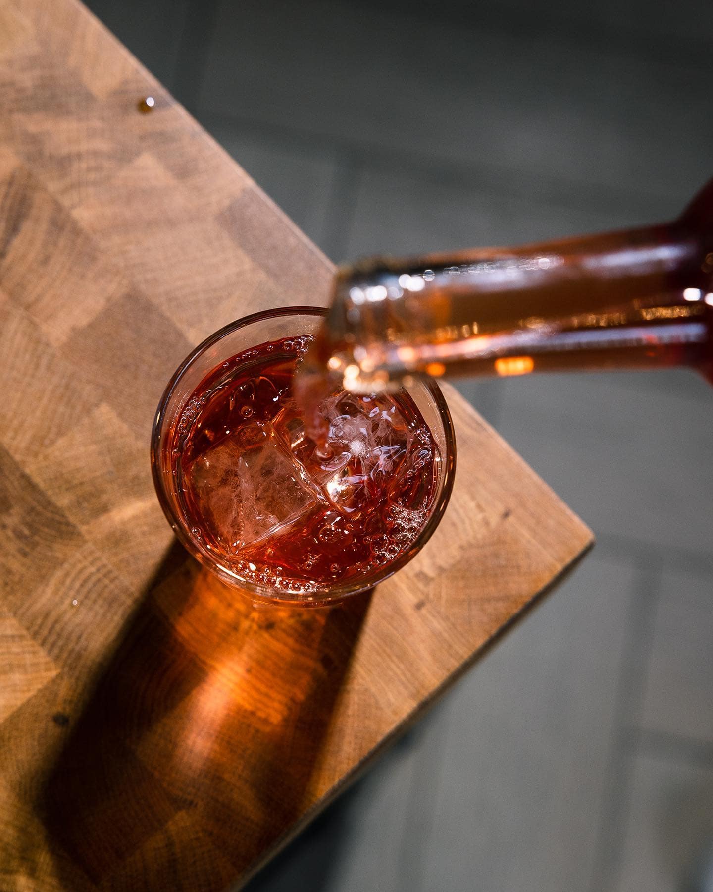 A red cocktail being poured behind the bar
