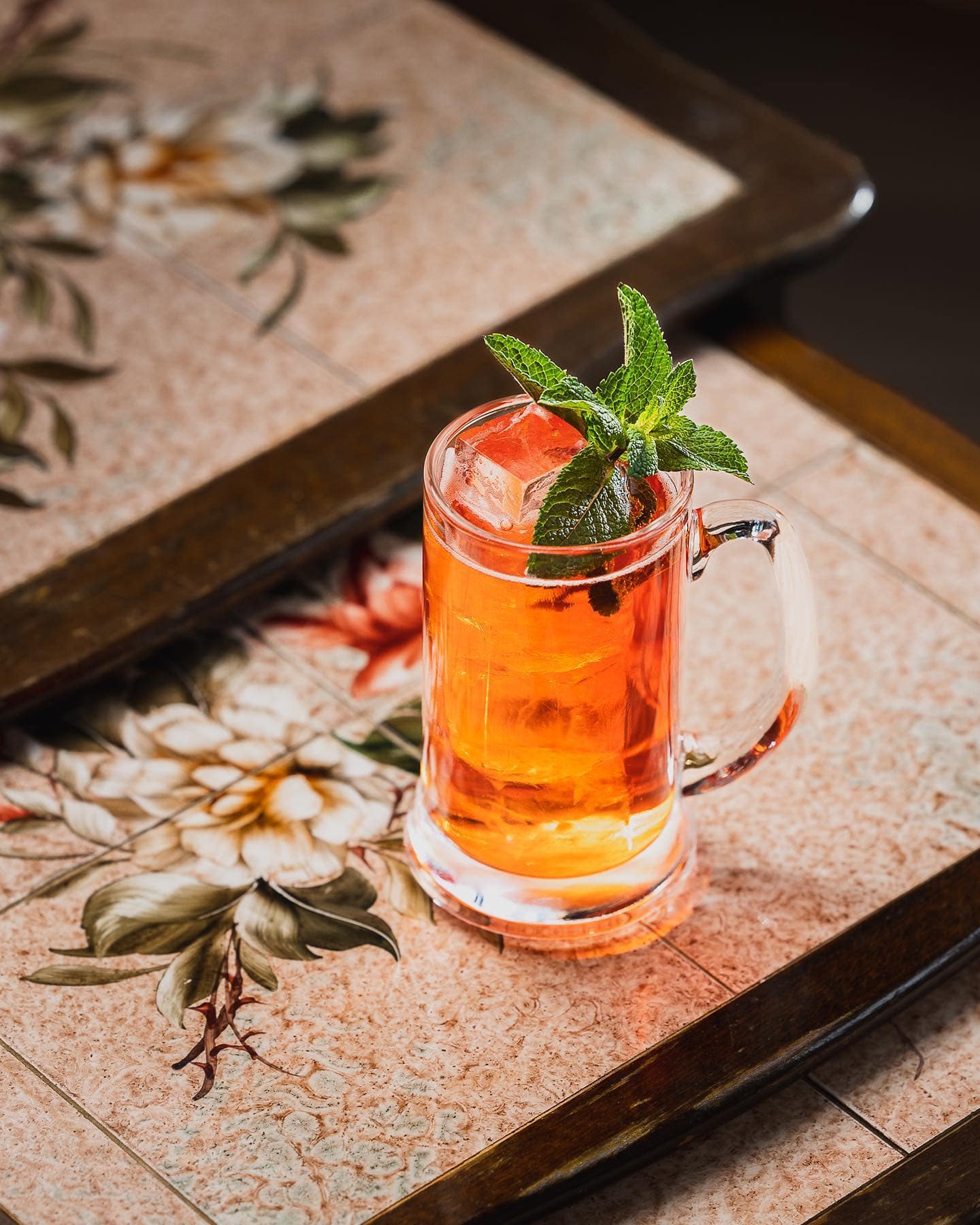 A frosted cocktail beside a jigger